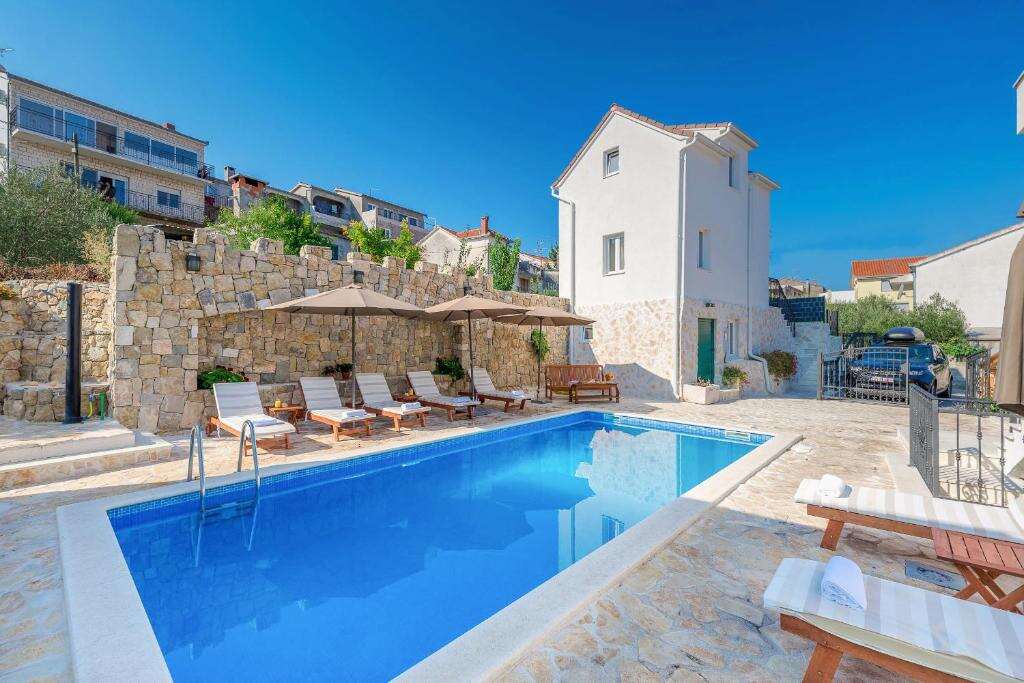 Outdoor pool with sun loungers at Villa Trau d`oro in Trogir